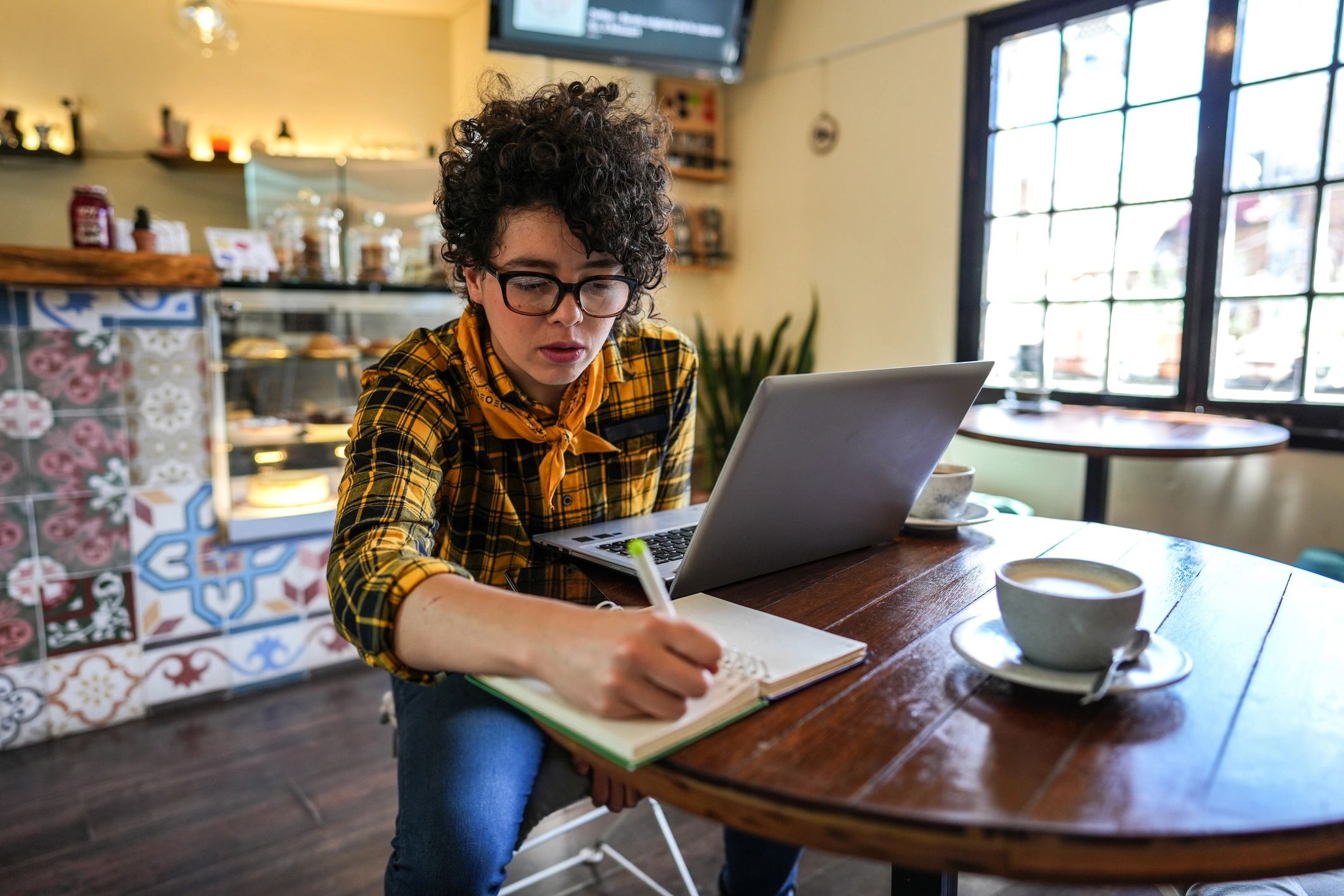 Woman studying with a laptop in a calm café setting