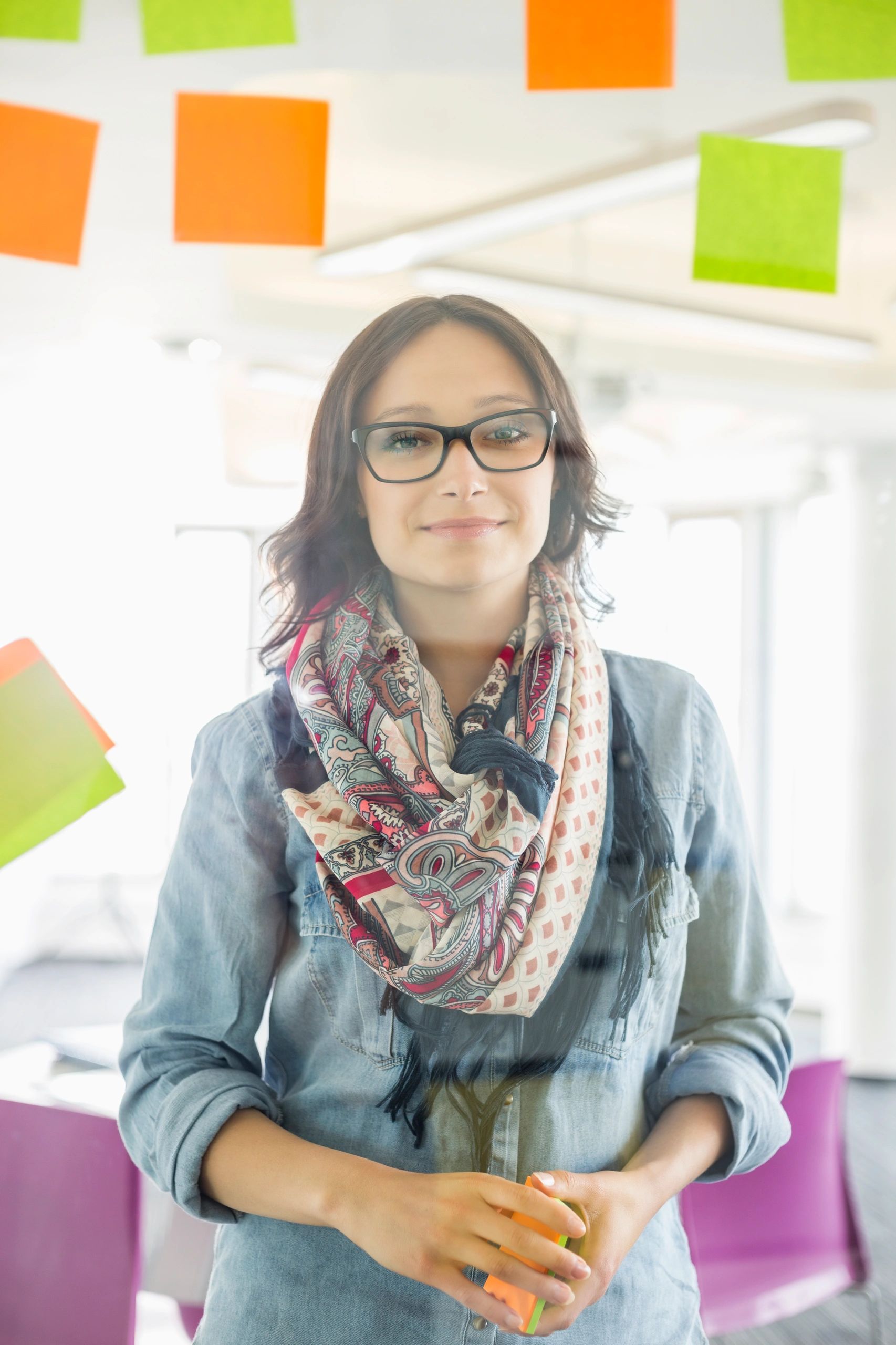Creative educator standing in a bright workspace with notes and ideas